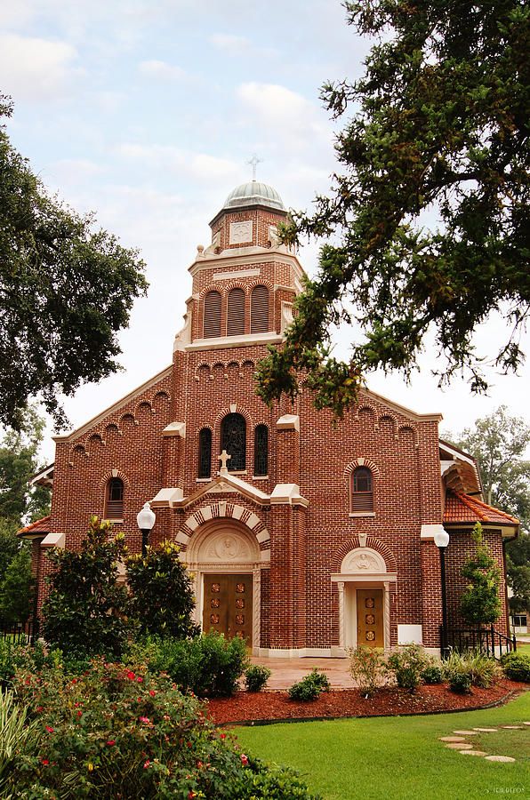 The red brick facade and bell tower of Sacred Heart Church in Moreauville, Louisiana
